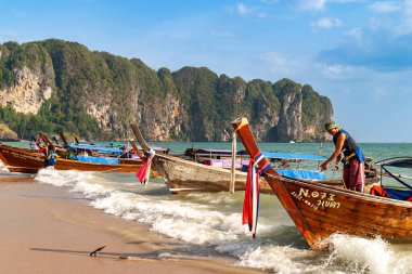 Geleneksel ahşap tekneler kumlu tropikal kıyı şeridi boyunca dinleniyor, Tayland, Krabi