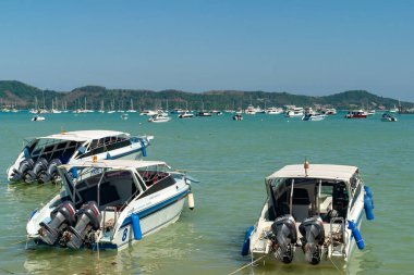 Tekneler Phuket sahilinde berrak sularda demirlemiş.