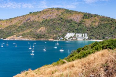 Tekneleri ve tepeleri olan Phuket adasının manzarası