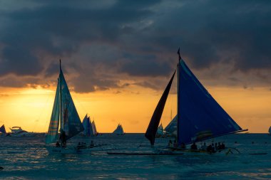Boracay, Filipinler - 08 Nisan 2018: Günbatımında White Beach 'te yelkenli tekneler ve tur tekneleri         