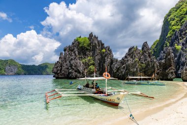 El Nido Körfezi, Palawan, Filipinler 'de Geleneksel Filipin Teknelerine Binen Turistler
