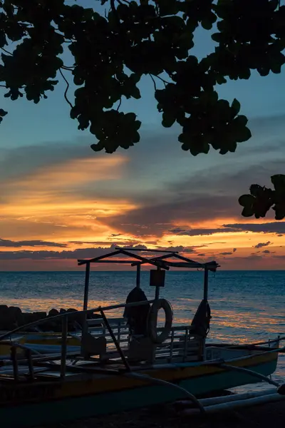 Parlayan ufuk ve sakin deniz dalgalarıyla huzurlu bir akşam kıyıda, Camiguin, Filipinler