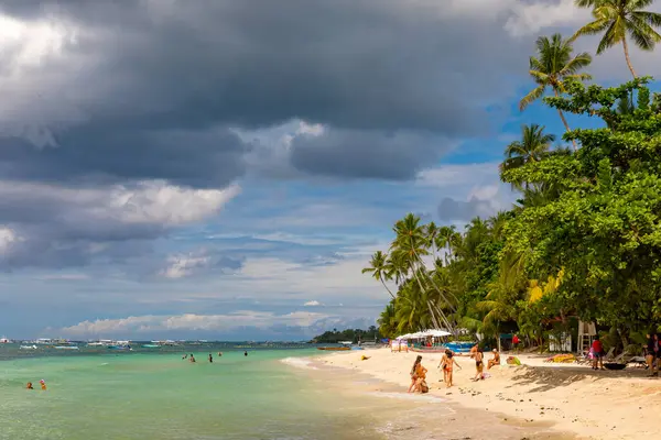 Panglao Adası, Bohol, Filipinler - 20 Nisan 2018: Alona Sahili 'nde güneş ve denizin tadını çıkaran tatilciler.