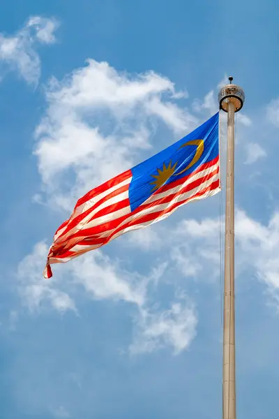 Güzel mavi gökyüzünde dalgalanan Malezya bayrağı