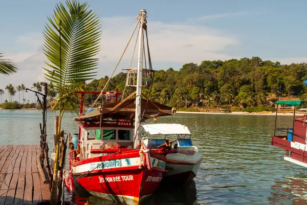 Bereketli ada kıyısı yakınlarındaki tropikal rıhtıma yanaşan renkli ahşap botlar, Koh Chang, Tayland