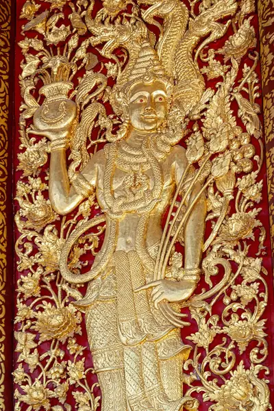 Tayland tapınağından bir kapı panelinde altın ahşap kabartma.. 
