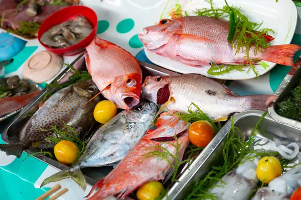 Fresh and raw fish displayed on trays at night market, Philippines