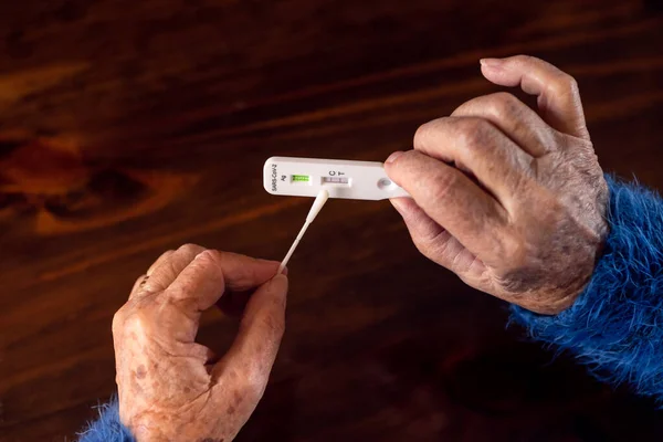 歳の女性の手のクローズアップは Covid19のための肯定的なテストデバイスを保持します 自宅で病気のコロナウイルスの迅速な検査を示す白人の祖母 祖母感染症検疫 — ストック写真