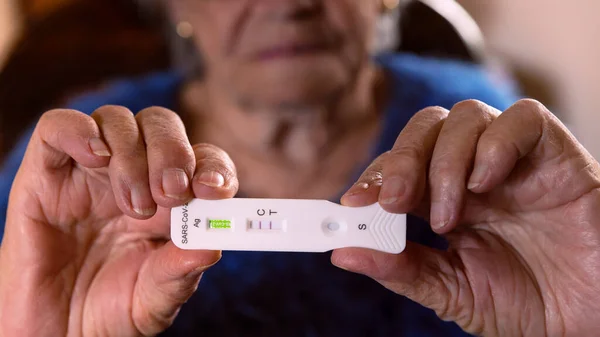 悲しい白人のおばあちゃんは Covid19ウイルスの迅速な家庭用テストデバイスを肯定的な結果にします 新しいOmicronバリアントウイルスのためのPcr式テストの抗原カセットを使用して不幸な祖母 — ストック写真