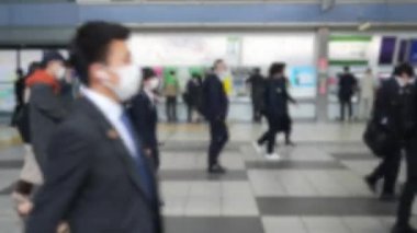 Metro istasyonundan yaya olarak geçen bir grup işçinin odak noktasından. Yoğun bir Japon işçi akıntısı işlerine doğru ilerliyor..