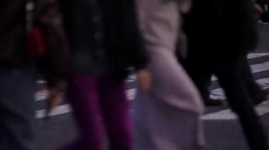 Tokyo, Japonya-10 Nisan 2023: Kalabalık ayaklar ve bacaklar ünlü Shibuya kavşağında, gece vakti yayanın hareketli akışını tasvir ediyor. Kaldırımda yayalar var.