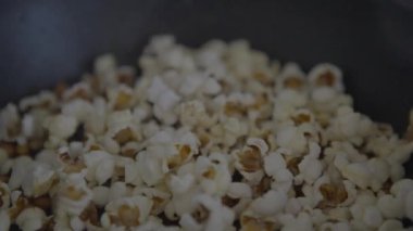 Slowmotion of homemade popcorn popping wildly from a frypan. Crunchy pop corn snack in cooked a pan.  delicious and tasty corns kernels almost popped with salt