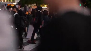 Tokyo, Japonya-10 Nisan 2023: Kalabalık kalabalık Shibuya kavşağında, enerjik gece vakti yaya akışını tasvir ediyor. Gürültülü gece sokakları