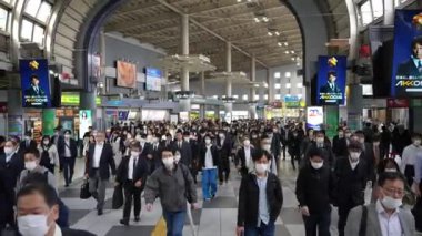 Tokyo, Japonya-12 Nisan 2023: Büyük bir Japon banliyö kalabalığı sabah trafiğinde metro istasyonunda işe doğru yürüyorlar. İşlerine giden profesyonellerin yoğun akışı.