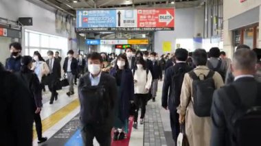Tokyo, Japonya-12 Nisan 2023: Büyük bir Japon banliyö kalabalığı sabah trafiğinde metro istasyonunda işe doğru yürüyorlar. İşlerine giden profesyonellerin yoğun akışı.