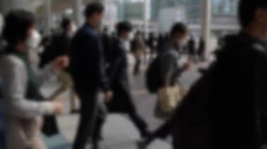 Japonya 'daki metro istasyonundan çıkan ve işe zamanında yetişmek için çabalayan bir grup insanın bulanık görüntüsü..