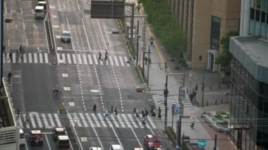 Tokyo, Japonya-13 Nisan 2023: Yukarıdan yavaş çekim, Asyalılar en işlek yol kavşağında yürüyor. Yaya uçakları Japon geçidinde yürüyor. Yaya geçidi.