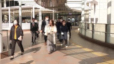 Yavaş çekim ve odak dışı çekim çok sayıda Japon banliyö çalışanı aynı anda işe gidiyor. Bir grup ofis çalışanı işyerlerine doğru koşuşturuyor..