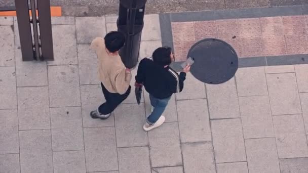 日本东京 2023年4月13日 两名男子手持手机在日本街头行走 从上方观看慢动作 手里拿着手机的日本人 — 图库视频影像