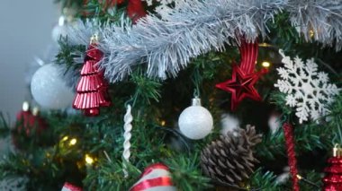 Bayram unsurlarıyla süslenmiş Noel baloları ve kar taneleri ağaçta asılı yemyeşil dallar güzel bir Noel süsü yaratıyor..