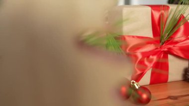 Ahşap masa bir Noel hediye kutusu ile süslenir, güzel dekore edilmiş bir tatil için zemin hazırlamak için neşeli ve süslü bir cazibe ile dolu.