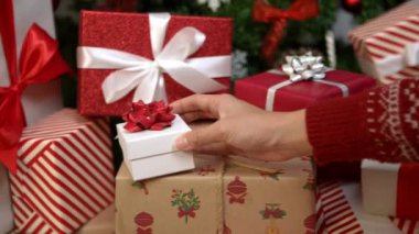 Genç Asyalı kadının yavaş çekimleri, güzel paketlenmiş bir hediye kutusunu tutarak bayram neşesini artırıyor, Çin 'deki evinde Noel kutlamasını artırıyor, neşeli tatil ruhunu artırıyor.