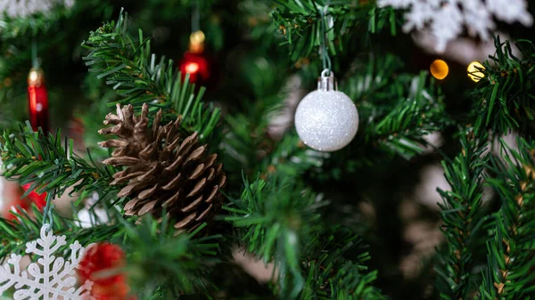 緑豊かな木の枝はXmasピネコネを加え クリスマスボールと雪片を美しくお祝いの装飾にします ロイヤリティフリーのストック画像