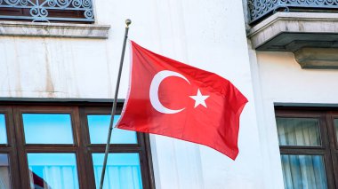 Pencereli geleneksel evde Türk bayrağı rüzgarda sallanıyor. Yumuşak ve pürüzsüz ipek hindi afişi yakın. Kumaş kumaş dokusu, Asteğmen. Ulusal gün konsepti için kullan..