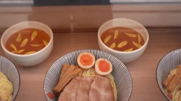 2023年4月10日2023年4月 サンプルとして知られる口水麺と風味豊かなスープの人工複製 レストランでは伝統的なアジア料理のプラスチックレンダリングを誇らしげに展示しています — ストック動画