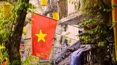 Vietnam 'ın kırmızı ulusal bayrağı ülkenin önemli bir sembolü olarak duruyor, sokaklarda dalgalanıyor ve ulusun ruhunu somutlaştırıyor..