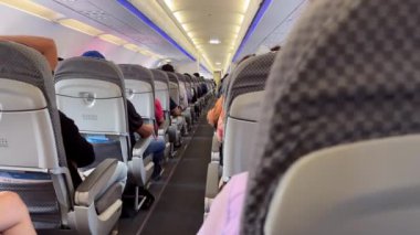 , -29 Mart 2024: Her iki tarafta da uçağın kalkmasını hevesle bekleyen yolcularla dolu bir uçak kabini bulunmaktadır. Havayolları çeşitli noktalara düzenli seferler düzenler.