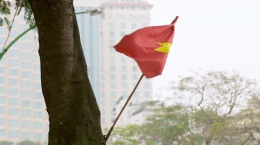 Vietnam, -01 Nisan 2024: Güçlü bir ulusal sembol olan kırmızı Vietnam bayrağı, Hanoi şehrinde bir caddede yüksekte dalgalanmakta, ülke kimliğini, mirasını ve gururunu temsil etmektedir..