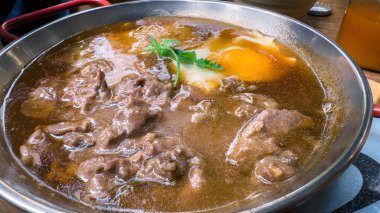 Bir kase yahni, Vietnamlı eti ve yumurtası, hepsi kişniş soslu, koyu bir sosta pişmiş. Geleneksel ve popüler bir Vietnam yemeği. Hanoi 'de yemek..