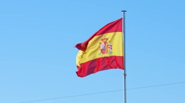 Mavi gökyüzüyle rüzgarda dalgalanan İspanyol bayrağı. İspanya afişi, yumuşak ve pürüzsüz ipek. Kumaş kumaş dokusu, Asteğmen. Ulusal gün ve ülke etkinlikleri konsepti için kullan..