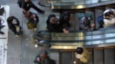 Tokyo 'nun Shibuya bölgesindeki metro yürüyen merdivenlerini dolduran kalabalığın görüntüsü bulanık. Japonya 'da yoğun saatlerde hareket halindeki merdivenleri kullanan Japon banliyö sakinleri