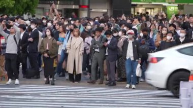 Tokyo, Japonya-10 Nisan 2023: Sahne Japonya 'daki Shibuya Geçidi' nde kendi yollarını çizen çok sayıda birey olarak gözler önüne seriliyor. Grup işlek şehirde yol alır.
