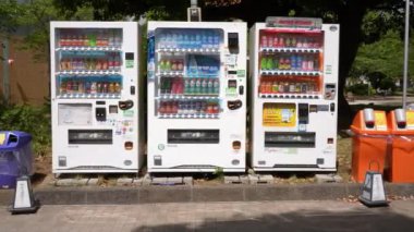Tokyo, Japonya-13 Nisan 2023: Japon içecek otomatı park üzerinde duruyor, insanlara sıcak bir gün için en iyi içeceği seçme seçeneği sunuyor. Otomatik dağıtıcı modern bir kolaylık sağlar.