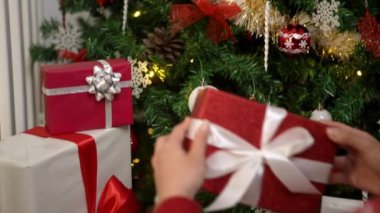 Yavaş çekimde Çinli bir kadın, Asya 'daki evinde Noel kutlaması için paketlenmiş bir hediye kutusu tutuyor. Bu da onu Asya' da şenlikli bir tatil yapıyor..