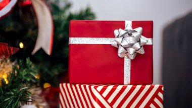 Yılbaşı süsleri ile tamamlanmış, çağdaş Noel ağacının altında, yılbaşı süsleri ile süslenmiş, temiz kırmızı paketlenmiş hediye kutuları..