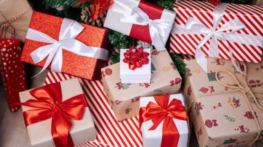 Yılbaşı süsleriyle süslenmiş çağdaş bir Noel ağacının altındaki hediye kutuları yeni yıl dekorasyonu için şenlikli bir ortam yaratır..