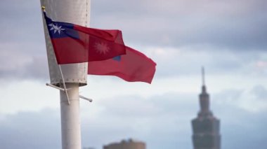 Tayvan ulusal bayrağının yavaş çekim görüntüsü. Taipei 101 arka planda yükseliyor, modernliği ve kültürel gururu simgeliyor..