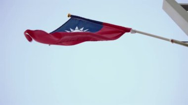 Alacakaranlıkta bir sokak direğine asılmış Tayvan bayrağının yavaş çekimleri gururu ve kültürel kimliği vurguluyor. Kentsel ve ulusal temalar için mükemmel.