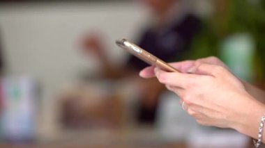 Mesajlaşmak için telefonu kullanan Asyalı bir kadın. Güneşli bir günde Tayvan 'da elinde akıllı telefon tutan biri. Kompozisyon modern yaşam tarzını ve dijital etkileşimi vurgular
