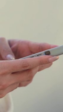 Taichung, Tayvan 'da bir alışveriş merkezinde akıllı telefon kullanan birinin dikey çekimi. Asyalı kadın mesaj atmak için telefonu kullanıyor. Sıcak atmosferi olan bir şehirde modern iletişim..