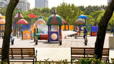 Bir işçi, Covid19 güvenlik önlemleri kapsamında Daan Park 'taki renkli bir oyun alanını dezenfekte ediyor. Şehir parkında halk sağlığı çalışmaları