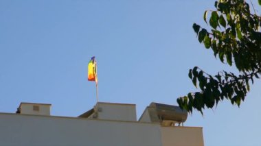 İspanya 'da gururla dalgalanan LGBTQ + gurur bayrağı, güneşli bir gökyüzüne karşı, kapsayıcılığı, özgürlüğü ve çeşitli bir toplumda gurur ruhunu simgeliyor..