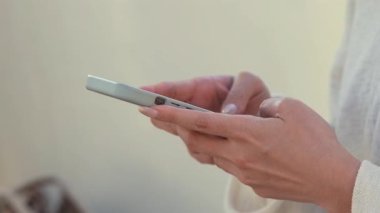 Taichung, Tayvan 'da bir alışveriş merkezinde akıllı telefon kullanan birinin yavaş çekimleri. Asyalı kadın mesaj atmak için telefonu kullanıyor. Parlak ve sıcak bir atmosferi olan bir şehirde modern iletişim..
