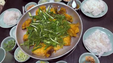 Kemiksiz ızgara hemibagrus balığı. Cha Ca La Vong Hanoi adında kızarmış bir nehir yayın balığı. Taze dereotu ve taze soğanlı restoranlar masası.