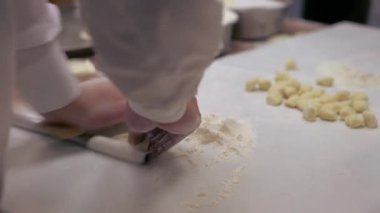 Tayvanlı bir aşçı hamuru düzleştirir ve geleneksel Çin hamur tatlısı olan Jiaozi 'yi pişirmek için eti etle doldurmaya hazırlanır. Asyalı bir adam restoranın mutfağında elle hamur köftesi yapıyor..