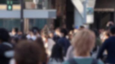 Japonya 'daki ünlü Shibuya Geçidi' ndeki kalabalık kalabalığın yoğun bir şekilde toplanmış ve hızlı bir şekilde caddelerde ilerleyişinin bulanık görüntüsü..